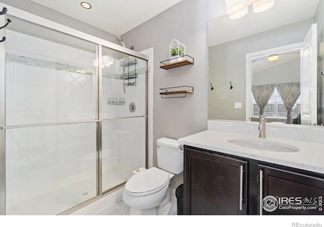 bathroom featuring a shower stall, vanity, and toilet