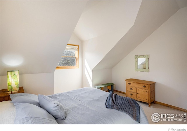 carpeted bedroom featuring baseboards and vaulted ceiling