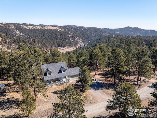 aerial view featuring a wooded view and a mountain view