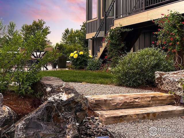 yard at dusk featuring stairway