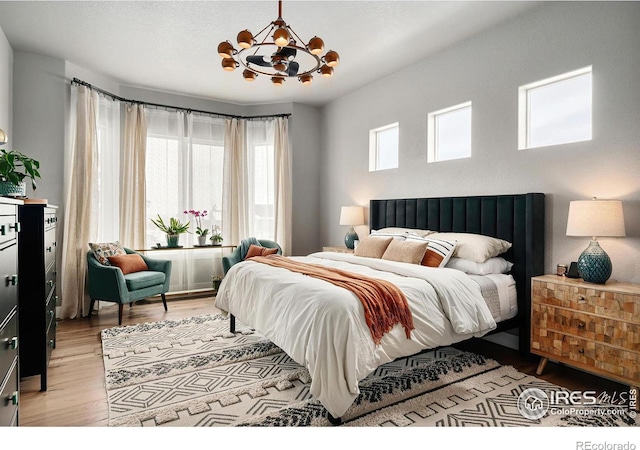 2025 Orchard Bloom Dr, Windsor, CO 80550 - bedroom with a chandelier and light wood-style floors
