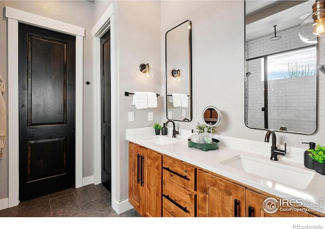 2025 Orchard Bloom Dr, Windsor, CO 80550 - bathroom featuring double vanity, tiled shower, and baseboards