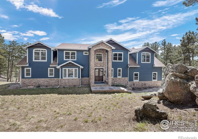 view of front of home featuring stone siding and a front yard