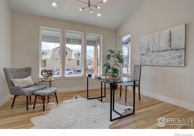 office space with a chandelier, lofted ceiling, baseboards, and wood finished floors