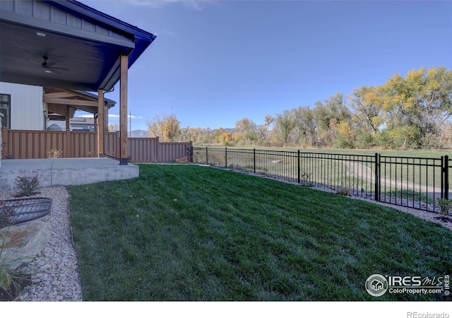 view of yard featuring ceiling fan, a fenced backyard, and a patio