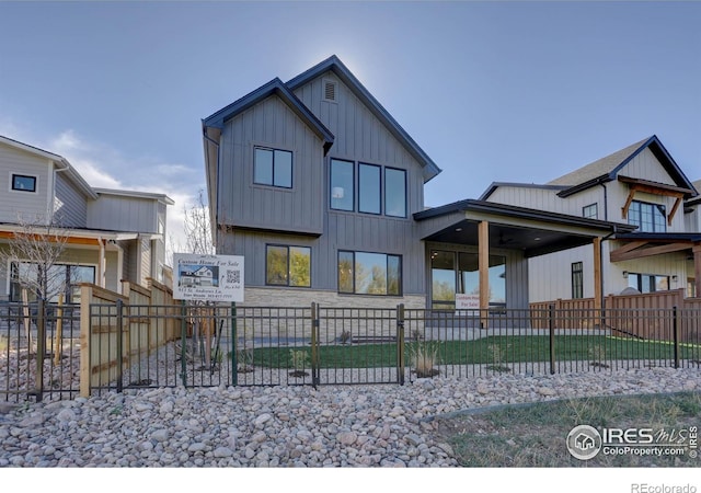 view of front facade with board and batten siding and fence private yard