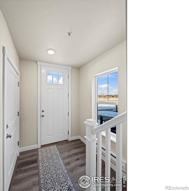 entryway with baseboards, dark wood finished floors, and a textured ceiling