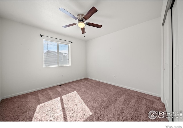 unfurnished bedroom with carpet floors, ceiling fan, baseboards, and a closet