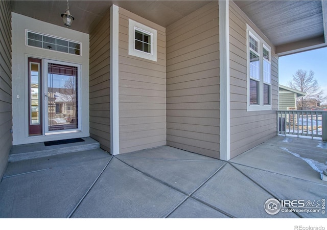 view of exterior entry featuring covered porch