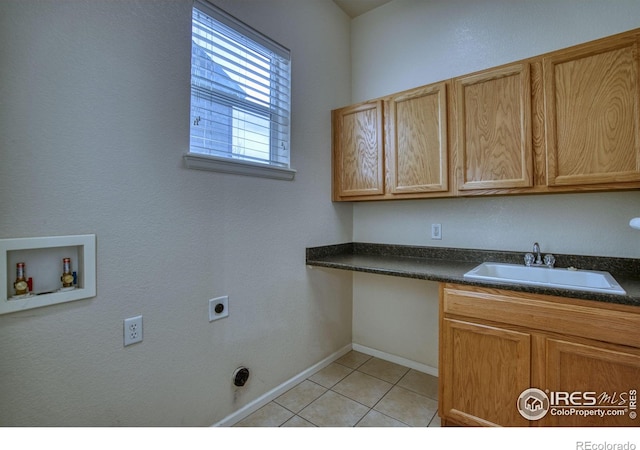 laundry area with cabinet space, light tile patterned floors, hookup for a washing machine, hookup for an electric dryer, and a sink