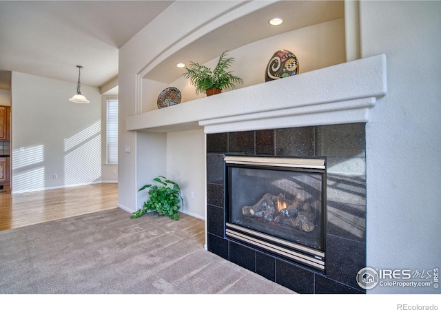 interior details featuring carpet floors, recessed lighting, a tiled fireplace, and baseboards