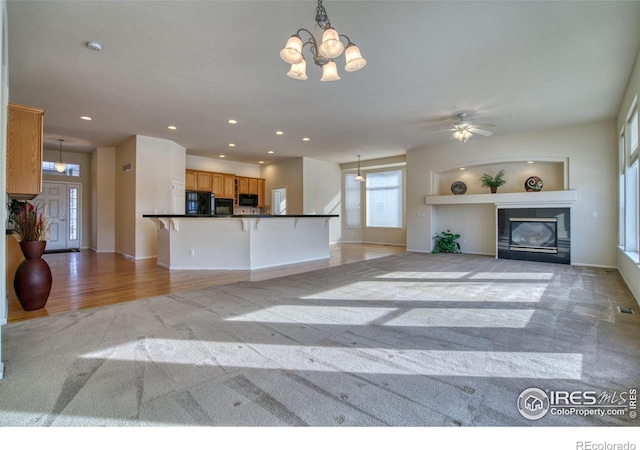 unfurnished living room with a tile fireplace, baseboards, recessed lighting, and an inviting chandelier