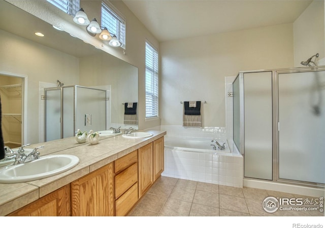 bathroom featuring tile patterned floors, a garden tub, a walk in closet, a shower stall, and a sink