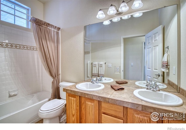 bathroom featuring shower / bath combination with curtain, double vanity, a sink, and toilet