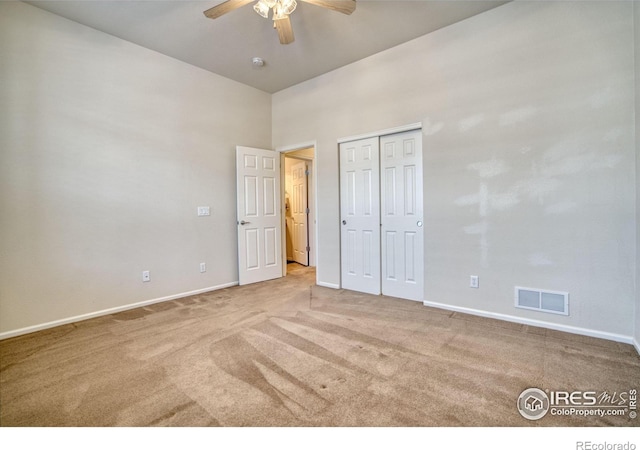 unfurnished bedroom featuring a ceiling fan, visible vents, light carpet, and baseboards