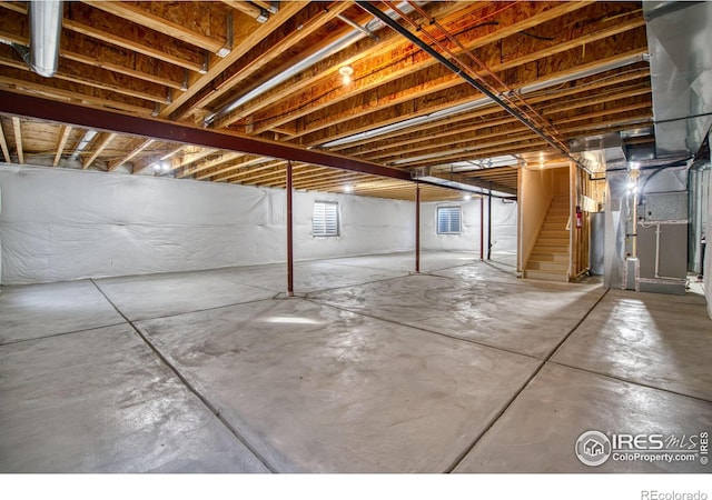 basement with heating unit and stairway