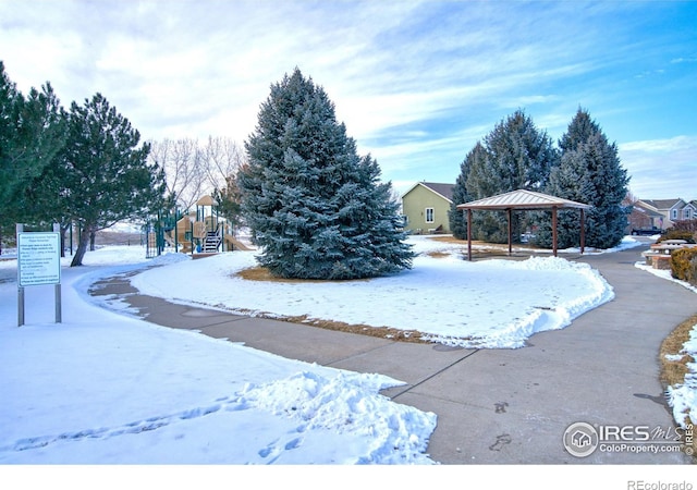 snowy yard with a playground and a gazebo