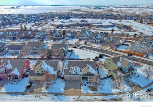 snowy aerial view with a residential view