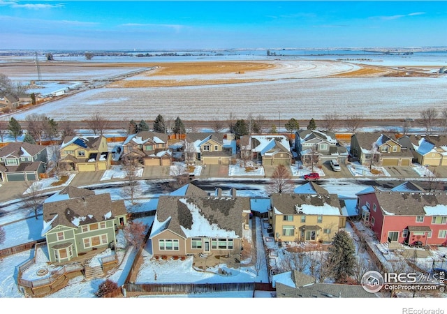 snowy aerial view with a residential view