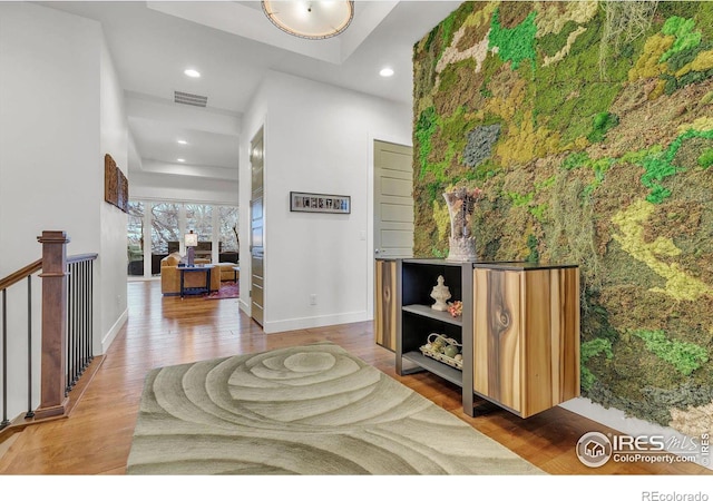 hall featuring baseboards, wood finished floors, visible vents, and recessed lighting