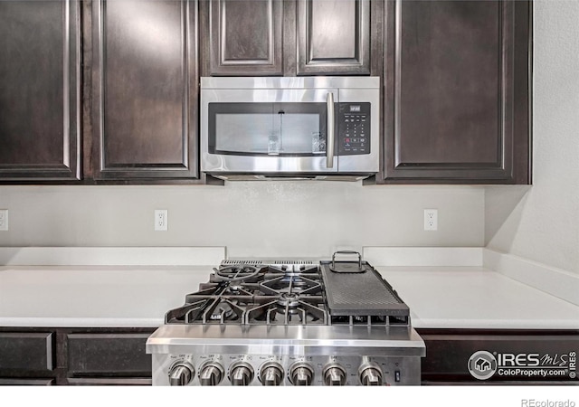 kitchen featuring cooktop, stainless steel microwave, light countertops, and dark brown cabinets