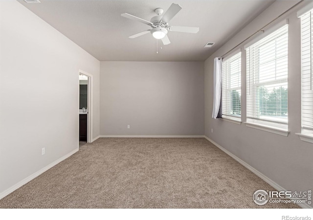 empty room with baseboards, carpet, visible vents, and a ceiling fan