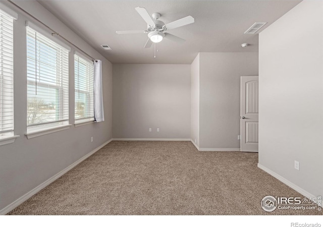 spare room featuring a ceiling fan, carpet, visible vents, and baseboards