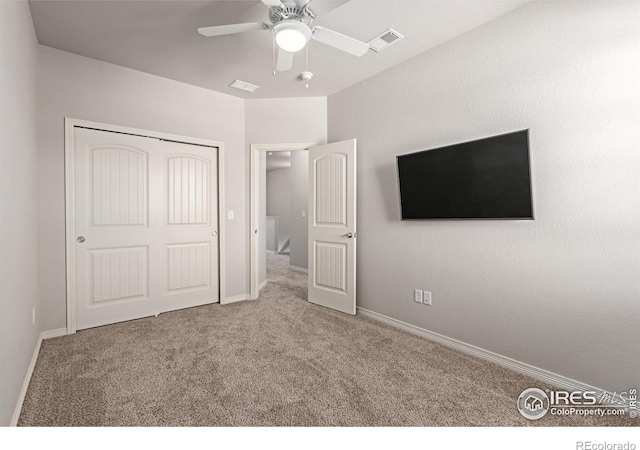 unfurnished bedroom with baseboards, visible vents, a ceiling fan, carpet floors, and a closet