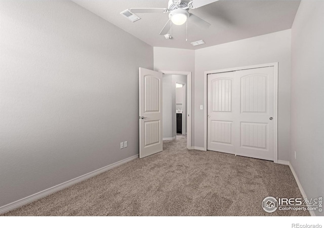 unfurnished bedroom with carpet floors, a closet, visible vents, and baseboards