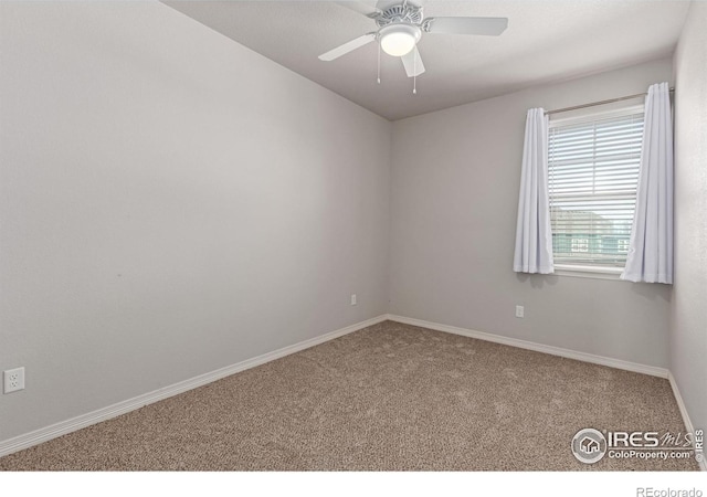 carpeted empty room with ceiling fan and baseboards