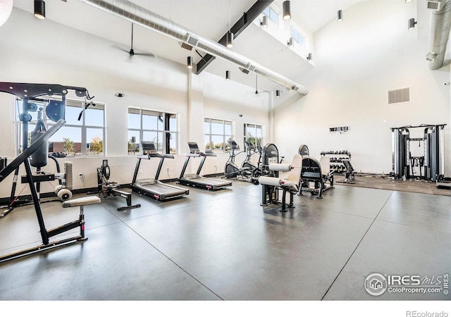 exercise room featuring visible vents and a towering ceiling