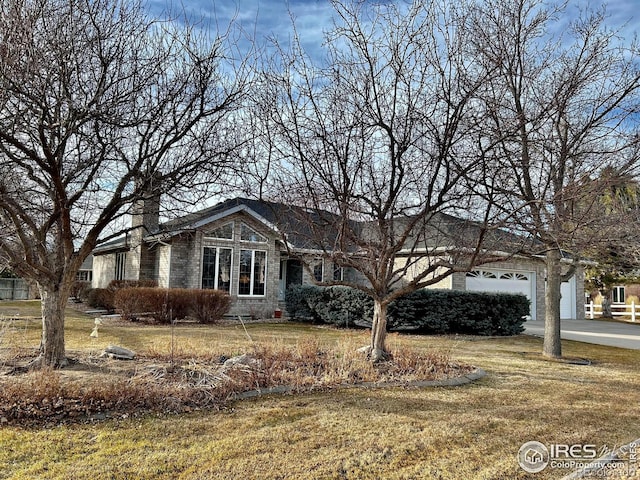 view of front facade featuring a garage, driveway, and a front lawn