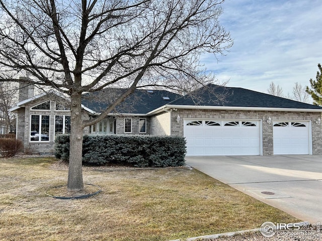 view of front of property with brick siding, a shingled roof, concrete driveway, a front yard, and a garage