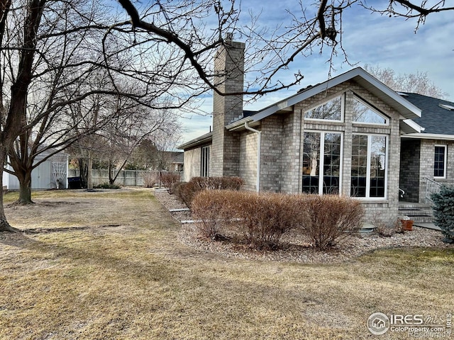 view of side of property with fence and a chimney