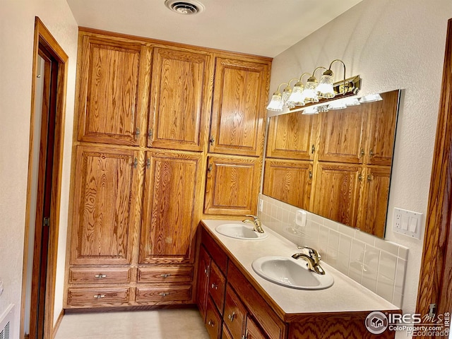 bathroom with double vanity, tasteful backsplash, visible vents, and a sink