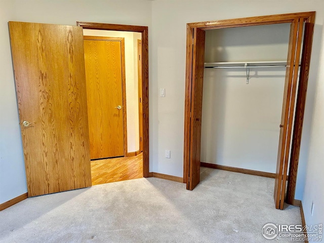 unfurnished bedroom with a closet, carpet, and baseboards