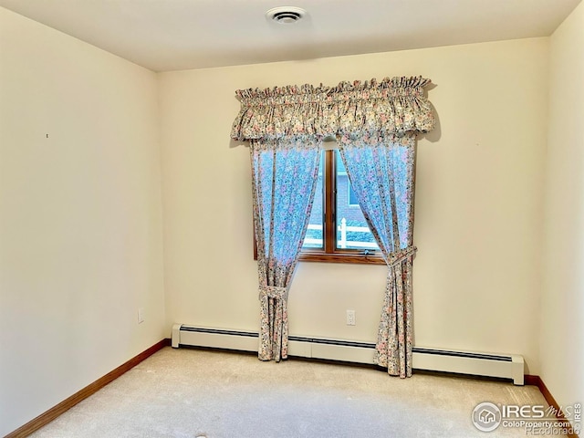 unfurnished room with a baseboard heating unit, visible vents, light carpet, and baseboards