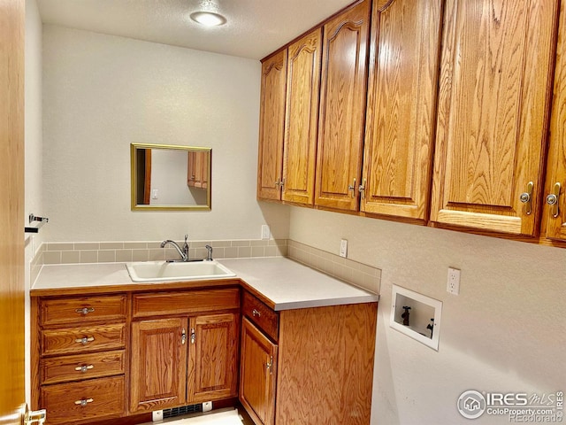 laundry area with a sink, hookup for a washing machine, visible vents, and cabinet space