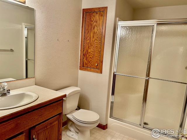 bathroom featuring vanity, a shower stall, toilet, and tile patterned floors