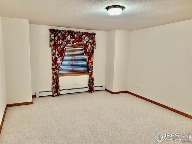 carpeted empty room with baseboard heating, a textured ceiling, and baseboards