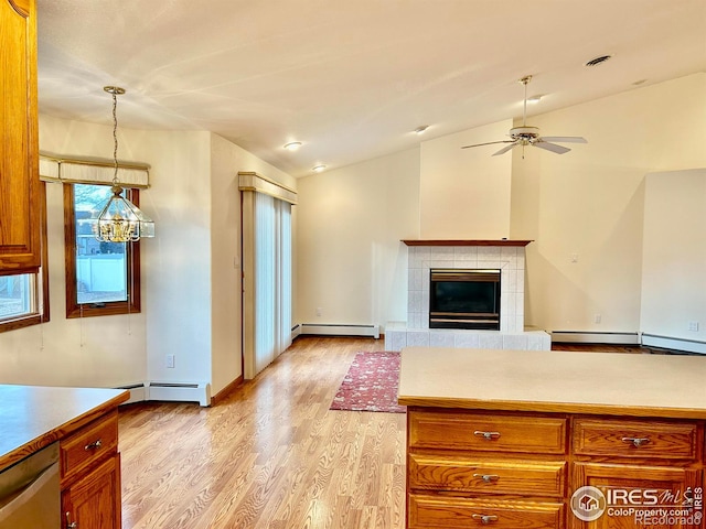 kitchen with a baseboard heating unit, visible vents, vaulted ceiling, stainless steel dishwasher, and light wood-type flooring