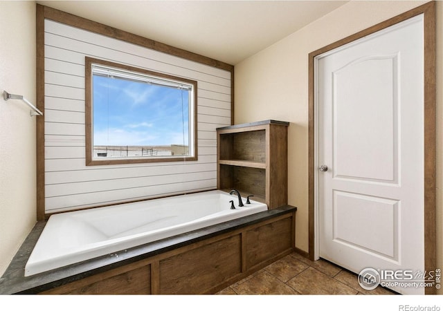 full bathroom with tile patterned floors, a garden tub, and wooden walls