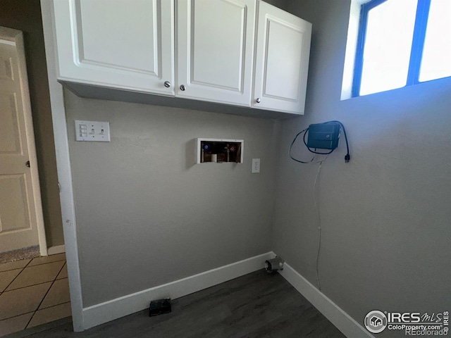 washroom with hookup for a washing machine, dark wood-style floors, baseboards, and cabinet space