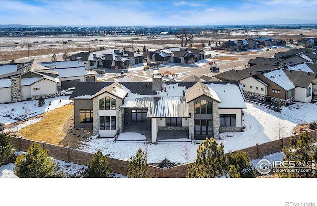 snowy aerial view featuring a residential view