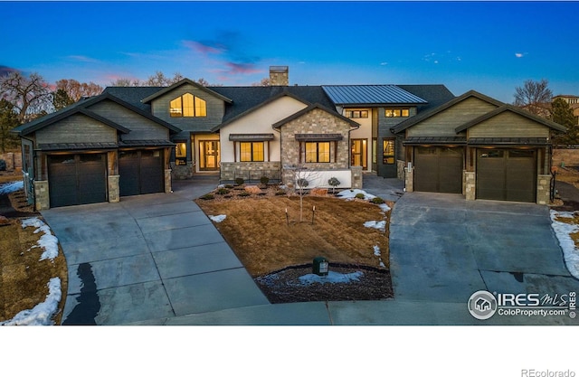 view of front of home featuring a garage, driveway, and a chimney