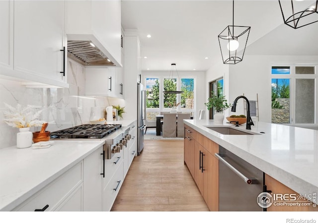 6398 Foundry Ct, Timnath, CO 80547 - kitchen featuring stainless steel appliances, a sink, light wood-style flooring, recessed lighting, and decorative light fixtures