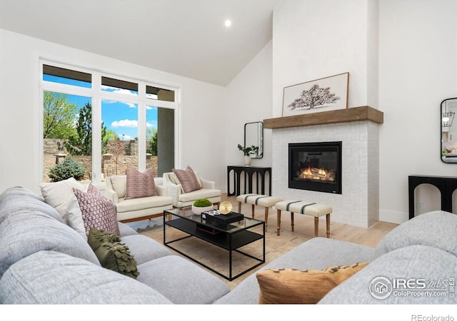 6398 Foundry Ct, Timnath, CO 80547 - living area with high vaulted ceiling, wood finished floors, a tile fireplace, baseboards, and recessed lighting