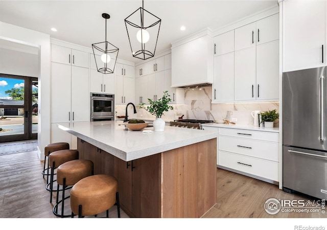 6398 Foundry Ct, Timnath, CO 80547 - kitchen featuring appliances with stainless steel finishes, light wood-type flooring, a kitchen breakfast bar, light countertops, and recessed lighting