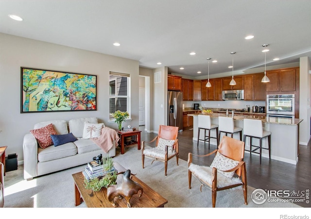 living area featuring recessed lighting, dark wood-style flooring, and baseboards