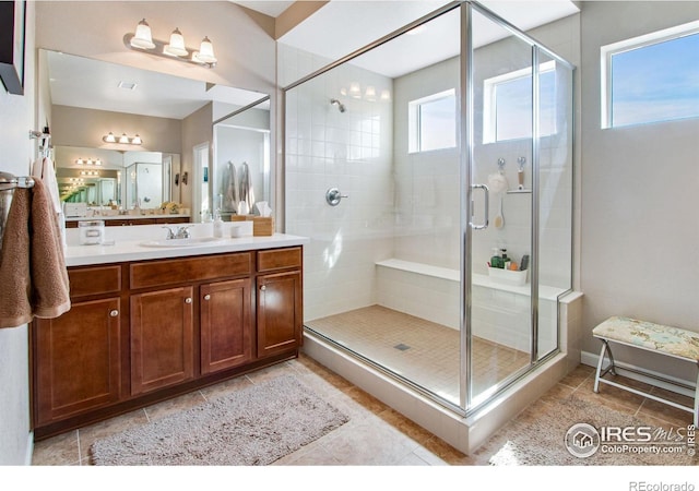 full bath featuring a stall shower, tile patterned flooring, and vanity